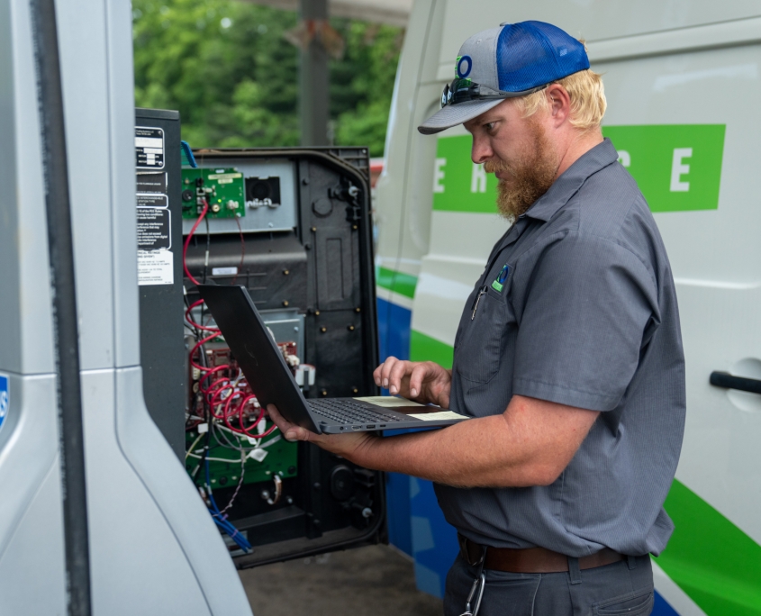 REO Service technician working at a gas pump.