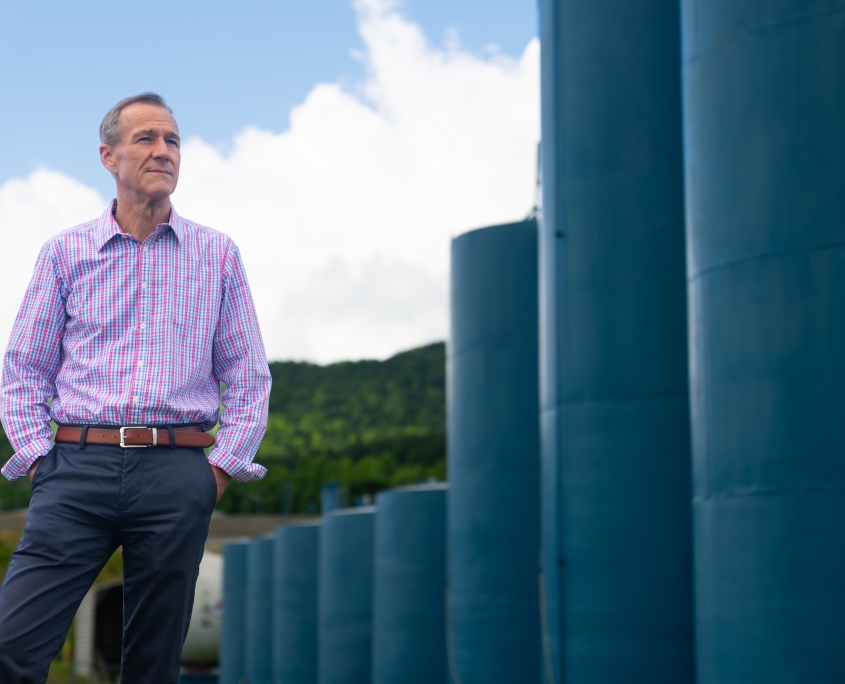 Tim Hutchens, owner of Hutchens Rentz-Eden, posing in front of fuel storage tanks.