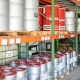 50 gallon metal drums of lubricant products on a metal shelf