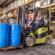 Hutchens team member driving a forklift loaded with a palette of 50 gallon drums containing lubricants