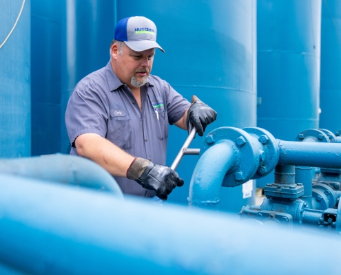 Hutchens team member working on blue oil pipiing