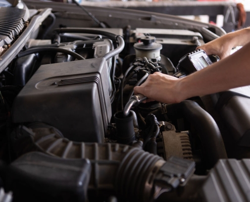 Mechanic changing the oil under the hood of a vehicle