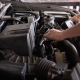 Mechanic changing the oil under the hood of a vehicle