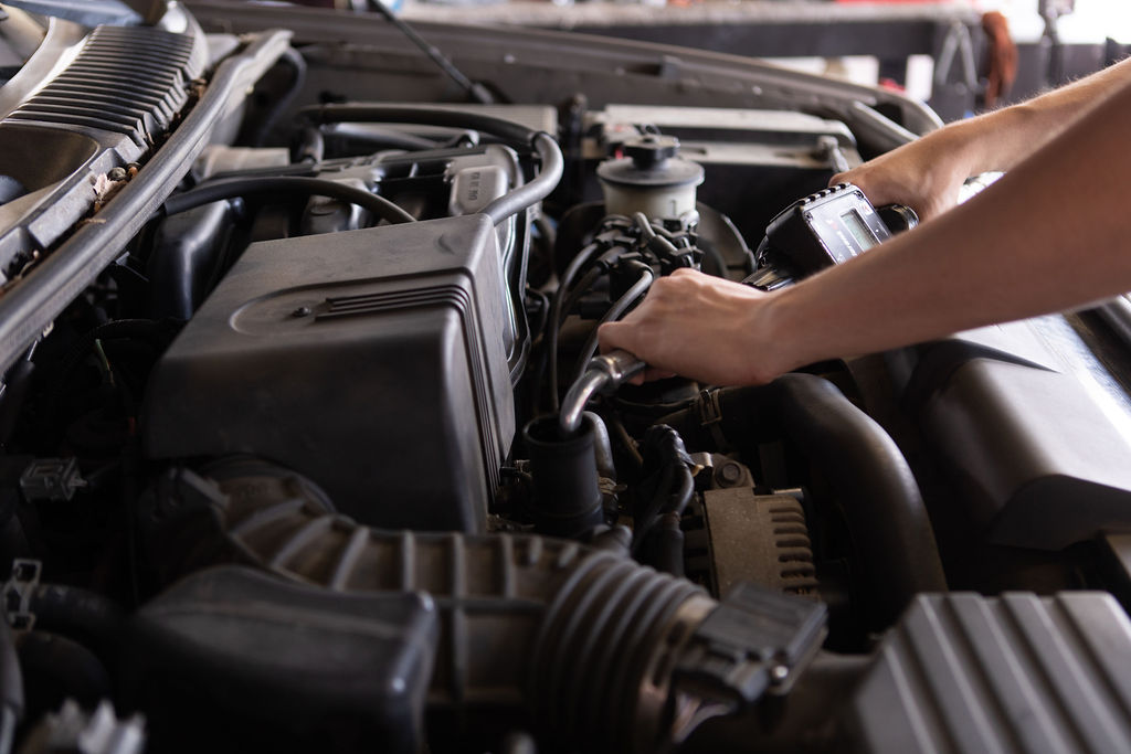 Mechanic changing the oil under the hood of a vehicle