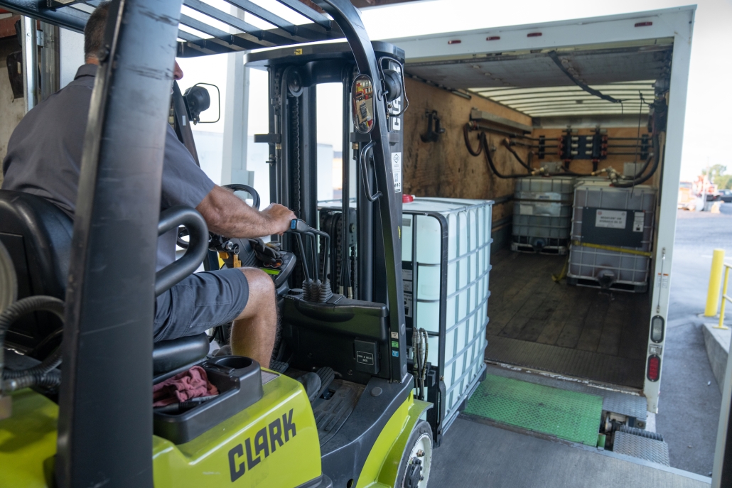 DEF Storage Totes being loaded onto a box truck by an HRE forklift operator.